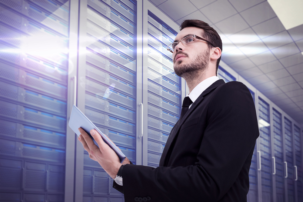 Businessman using tablet against computer server room